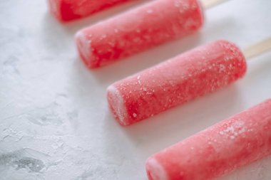 Beyaz arka planda pembe meyveli buzlu şerbet. Dondurma çubuğu. Kapatın. Yüksek kalite fotoğraf