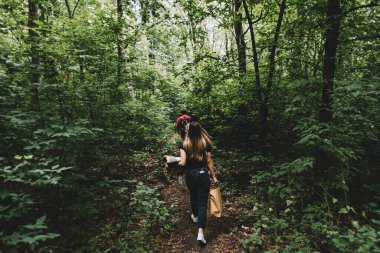 Bir grup arkadaş piknik için ormanda bir patika boyunca yürüyorlar. Kamp, yürüyüş konsepti. Yüksek kalite fotoğraf