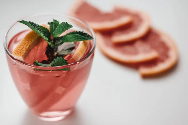 Pink drink, cocktail with grapefruit slice and fresh mint on a white background. High quality photo