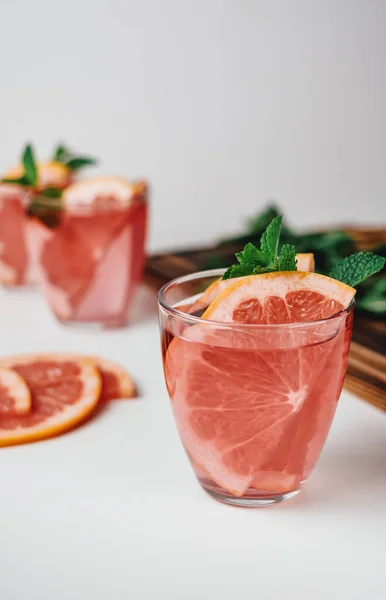 Pink drink, cocktail with grapefruit slice and fresh mint on a white background. High quality photo