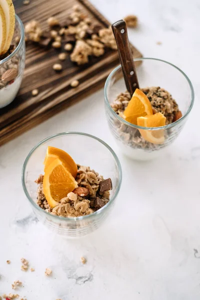 Muesli e iogurte natural com fatias de frutas e nozes em uma xícara de vidro — Fotografia de Stock