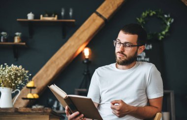 Genç beyaz sakallı adam mutfakta kitap okuyor. Ev tatili. Yüksek kalite fotoğraf