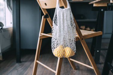 Taze meyveli bir ağ mutfaktaki ahşap bir sandalyede asılı. Mutfak İç İşleri. Yüksek kalite fotoğraf