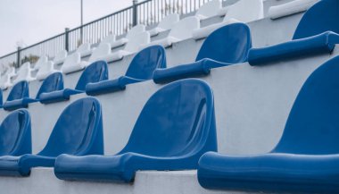 Açık havada mavi ve beyaz koltukları olan boş tribünler. Yüksek kalite fotoğraf