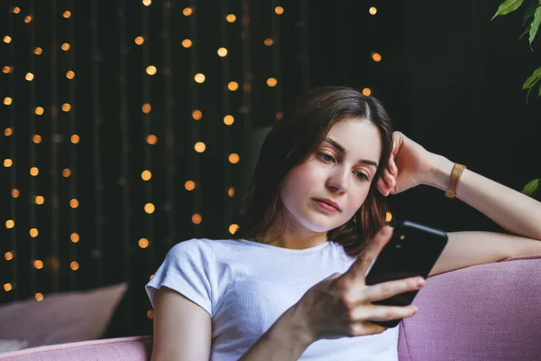 Joven Mujer Caucásica Pensativa Utilizar Teléfono Inteligente Mientras Está Sentado — Foto de Stock