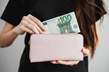 Genç bir kadın deri bir cüzdandan euro banknotları çekiyor. Kapatın. Yüksek kalite fotoğraf