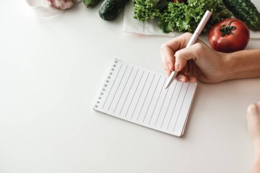 Kadın not defterine, alışveriş listesine ya da yemek tariflerine not alır. Model yap. Yüksek kalite fotoğraf