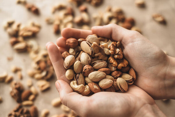 Different types of nuts, nut mix of almonds, hazelnuts, cashews, peanuts in hands. . High quality photo