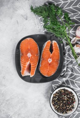 Gri tabakta baharatlı, otlu ve limonlu taze somon balığı biftekleri. Sağlıklı yiyecekler. Düz Yat. Yüksek kalite fotoğraf