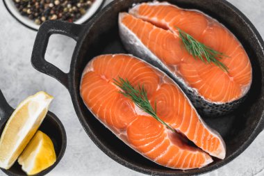 Siyah tavada baharatlı, otlu ve limonlu taze somon balığı biftekleri. Yüksek kalite fotoğraf