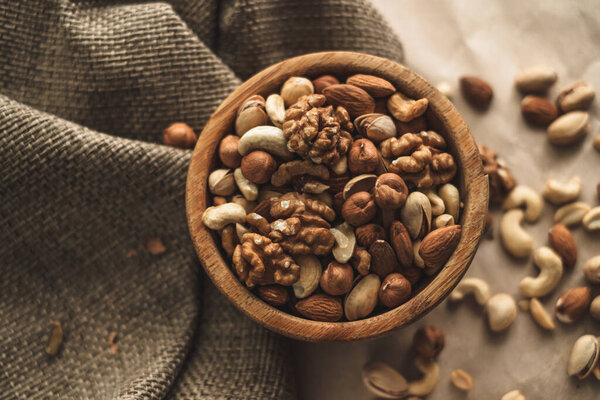 Different types of nuts, nut mix of almonds, hazelnuts, cashews, peanuts in a wooden bowl. Close up. High quality photo