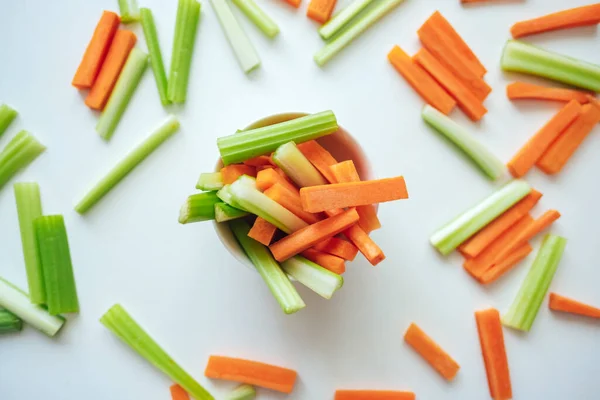 Sliced carrots and celery in a white bowl, healthy food, recipe background. High quality photo