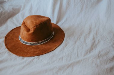 Beyaz yatakta kovboy şapkası. Yüksek kalite fotoğraf