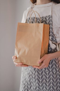 Kadın, eco alışveriş poşetini elinde tutuyor ve götürüyor. Yemek teslimatı, taklit et. Yüksek kalite fotoğraf