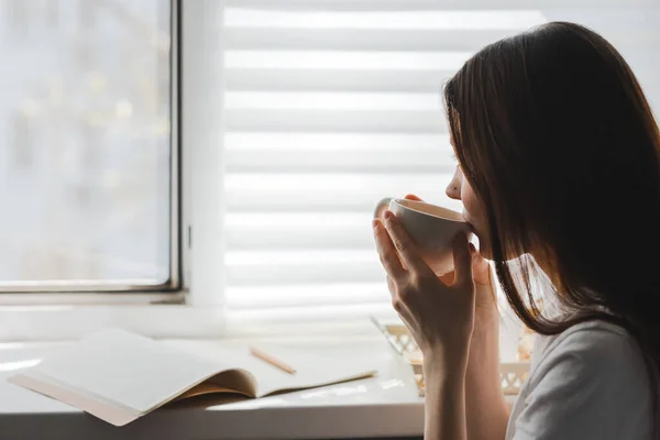 Woman Drinking Tea Sitting Window Takes Notes Sunny Spring Morning — Stock Photo, Image