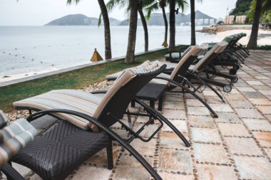 Plajda, deniz kenarında, palmiye ağaçlarının altında boş güneşlikler. Tropik bölgelerde tatiller. Yüksek kalite fotoğraf