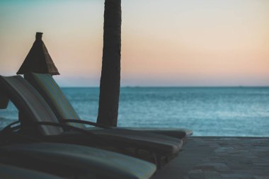 Gün batımında deniz kenarındaki terasta boş güneş pansiyonları. Yüksek kalite fotoğraf