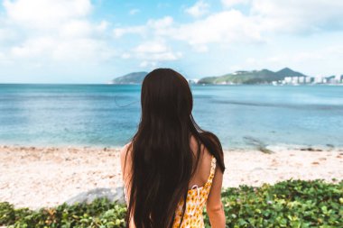 Genç beyaz kadın tropikal bir bahçede denize giden bir yolda yürüyor. Tropik tatil. Yüksek kalite fotoğraf