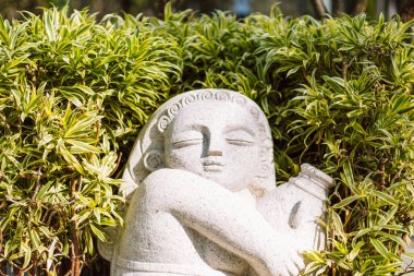 Bahçesinde bir şişe su olan bir kızın heykeli. Asya kültürü