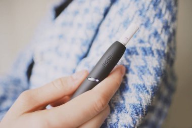 IQOS 3 kadın elinde ısıtma tütün sistemi. Yüksek kalite fotoğraf