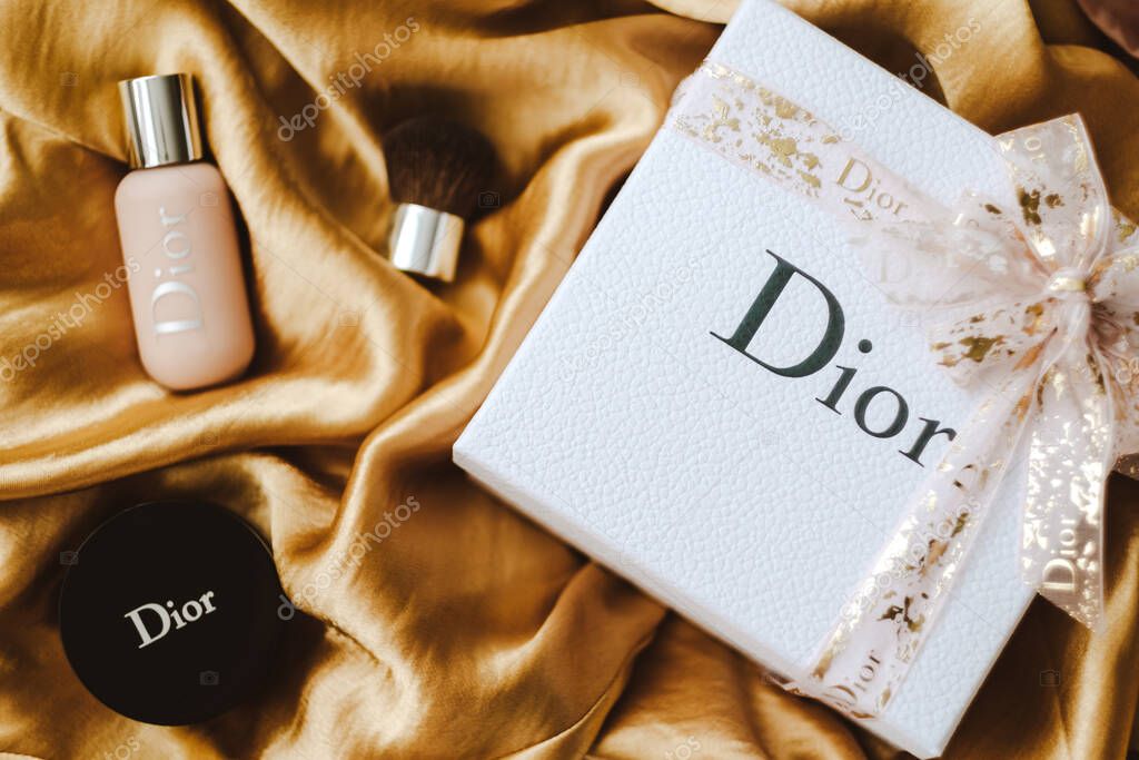Gift box from DIOR with makeup on a golden fabric. High quality photo