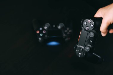 Sony Playstation 4 oyun joystickleri ellerinde fotokopi alanı ile siyah arkaplanda. Yüksek kalite fotoğraf