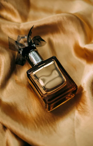 Butelka Perfum Złotej Satynowej Tkaninie Zbliżenie Ciepłe Światło Wysokiej Jakości — Zdjęcie stockowe