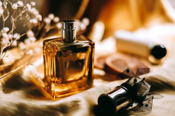 Butelka Perfum Złotym Satynowym Materiale Suszonymi Białymi Kwiatami Plasterkami Pomarańczy — Zdjęcie stockowe
