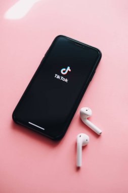 Ekranında TikTok uygulaması logosu olan iPhone. pembe arka plan. Yüksek kalite fotoğraf