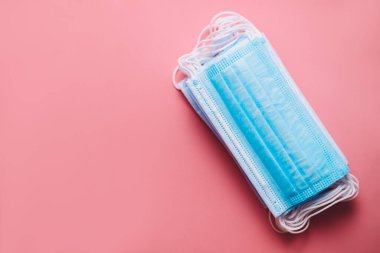 Pembe arka planda izole edilmiş tıbbi koruyucu maskeler. Kirliliğe karşı tıbbi maske koruması, virüs, grip, öksürük ve koronavirüs. Yüksek kalite fotoğraf