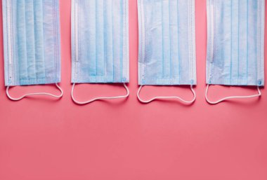 Pembe arka planda izole edilmiş tıbbi koruyucu maskeler. Kirliliğe karşı tıbbi maske koruması, virüs, grip, öksürük ve koronavirüs. Yüksek kalite fotoğraf