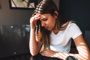 Dizüstü bilgisayarın önünde çalışan hayal kırıklığına uğramış genç bir kadın kronik baş ağrıları, online tedavi, tıbbi danışmanlık randevusu yaşıyor. Yüksek kalite fotoğraf