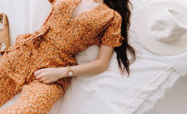 Güneşli bir sabahta güzel, genç ve şık bir kadın yatakta yatıyor..