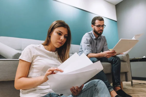 A young couple manages finances by looking through their bank accounts