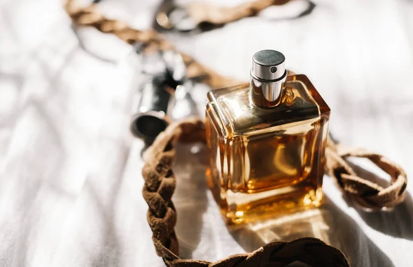 Gouden Parfum Fles Witte Stof Achtergrond Met Bruine Gevlochten Lederen — Stockfoto