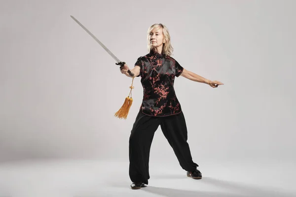 Mujer Rubia Madura Practicando Tai Chin Con Espada Fondo Blanco — Foto de Stock