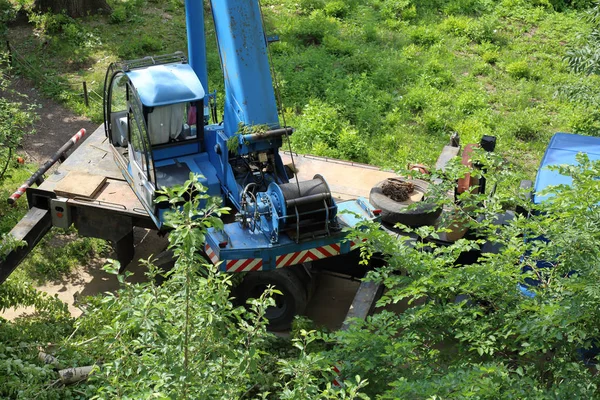 Winch with steel cable on the truck with a construction crane