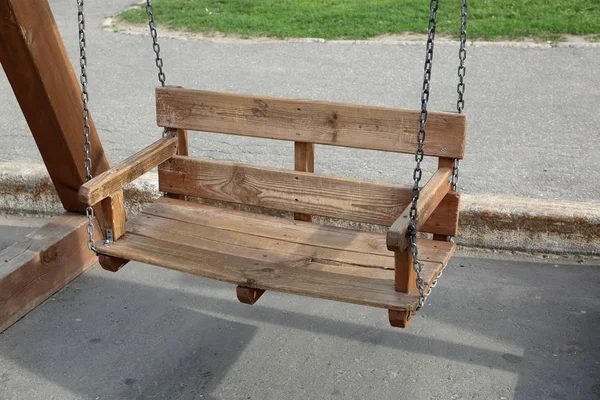 Homemade swing from rough boards on iron chains