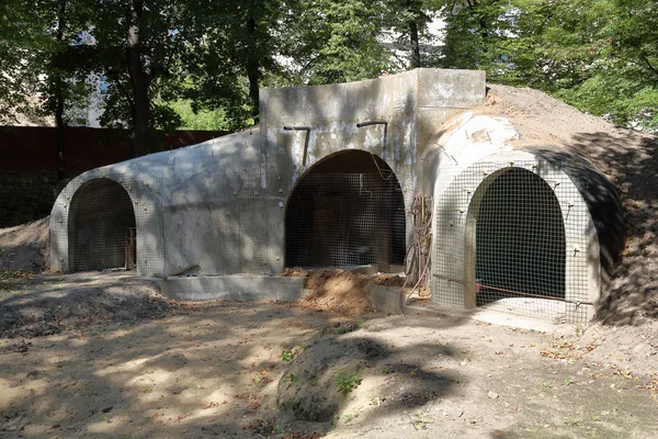 An abandoned bomb shelter with arches and soil embankment