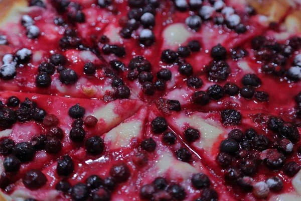 Delicious dessert pizza with wild berries and sugar powder