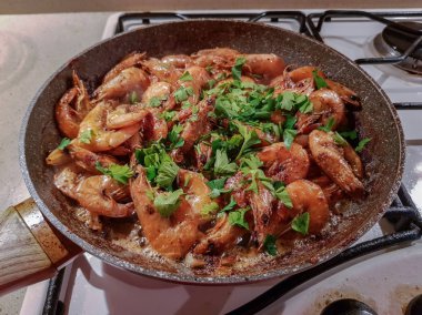 Yağı bir tavada bir gaz sobası üzerinde başlı dev portakal karides kızarmış