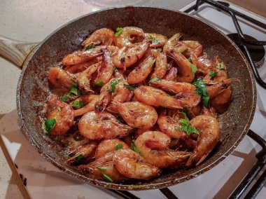 Yağı bir tavada bir gaz sobası üzerinde başlı dev portakal karides kızarmış