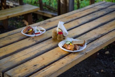 Sebze ve ahşap bir masa üzerinde plastik tabakta ekmek ızgara alabalık