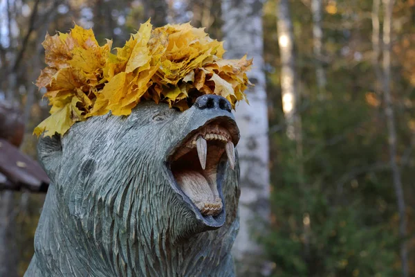 木製クマ ニヤリと顎と黄色のカエデの葉します — ストック写真