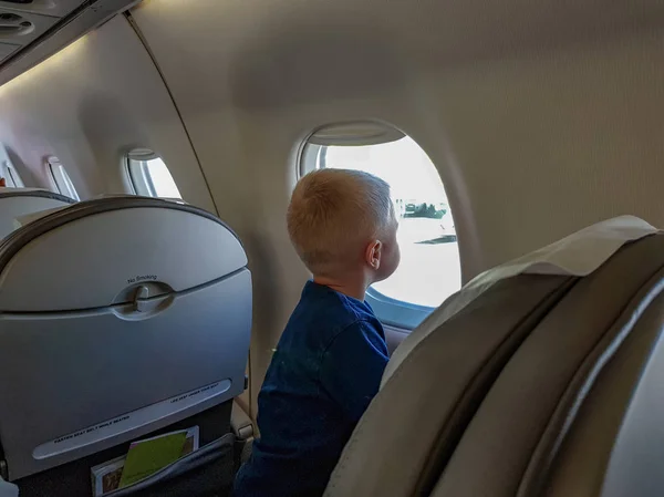 Little Blond Boy Looks Out Porthole Passenger Plane — Stock Photo, Image