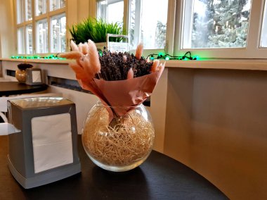 Bir tabloda bir kafede dekoratif kuru bitkiler ile küresel aranjman