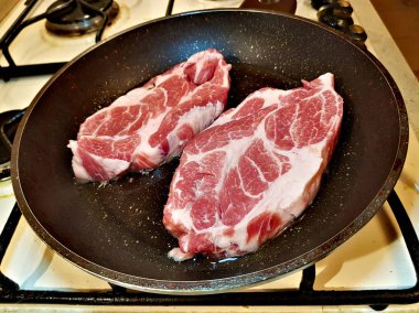 Zeytin yağı bir tavada kızartılmış yağlı sulu domuz eti