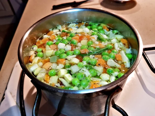 胡萝卜和芹菜的煮蔬菜汤是在家里的煤气炉上的平底锅里煮的 — 图库照片