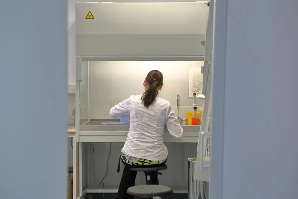 La ragazza con un cappotto bianco in laboratorio — Foto Stock