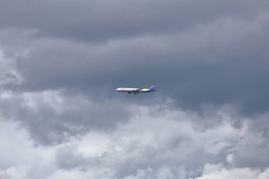 Gri bulutlu gökyüzünde yolcu uçağı